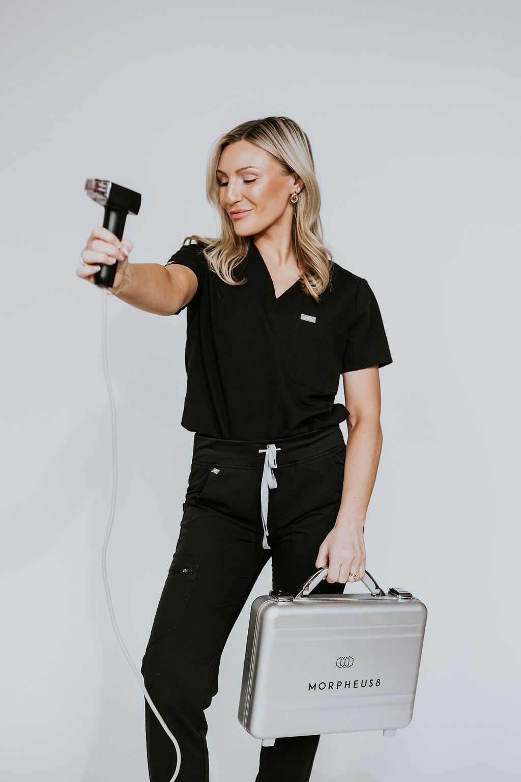 A skilled aesthetician at Hue Aesthetics in Louisville, Kentucky, posing with the Morpheus8 radiofrequency equipment, ready to deliver non-surgical skin rejuvenation treatments.